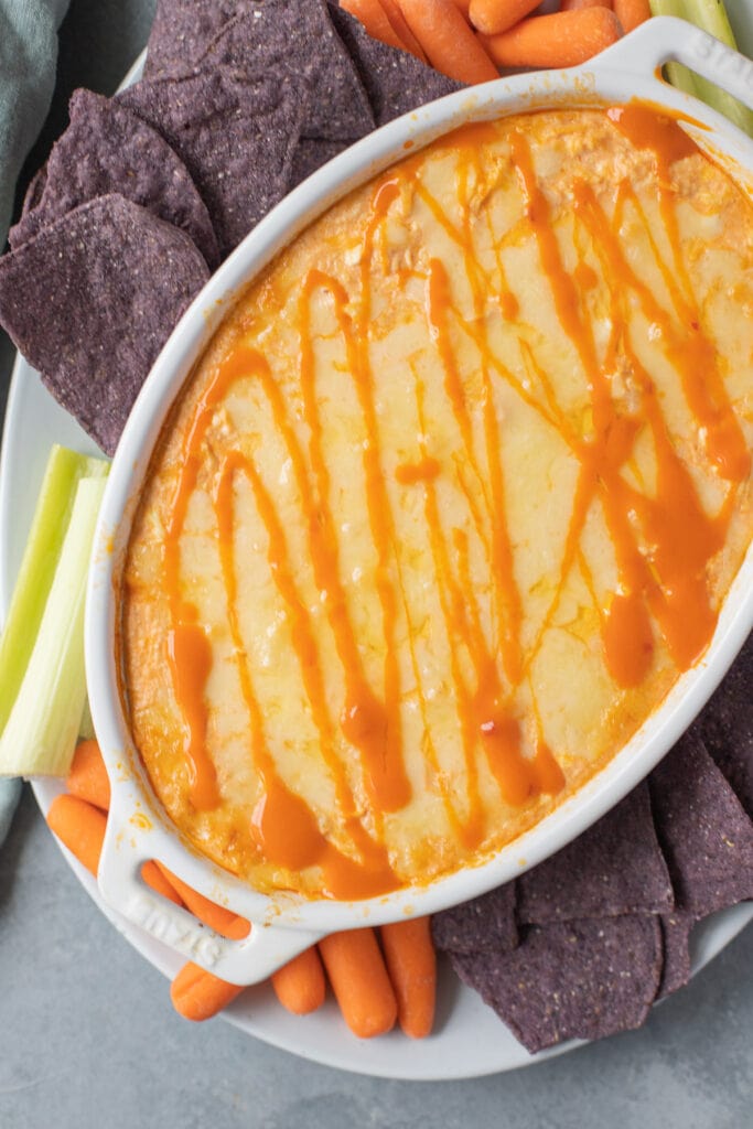 healthy buffalo chicken dip in a white dish fresh out of the oven.