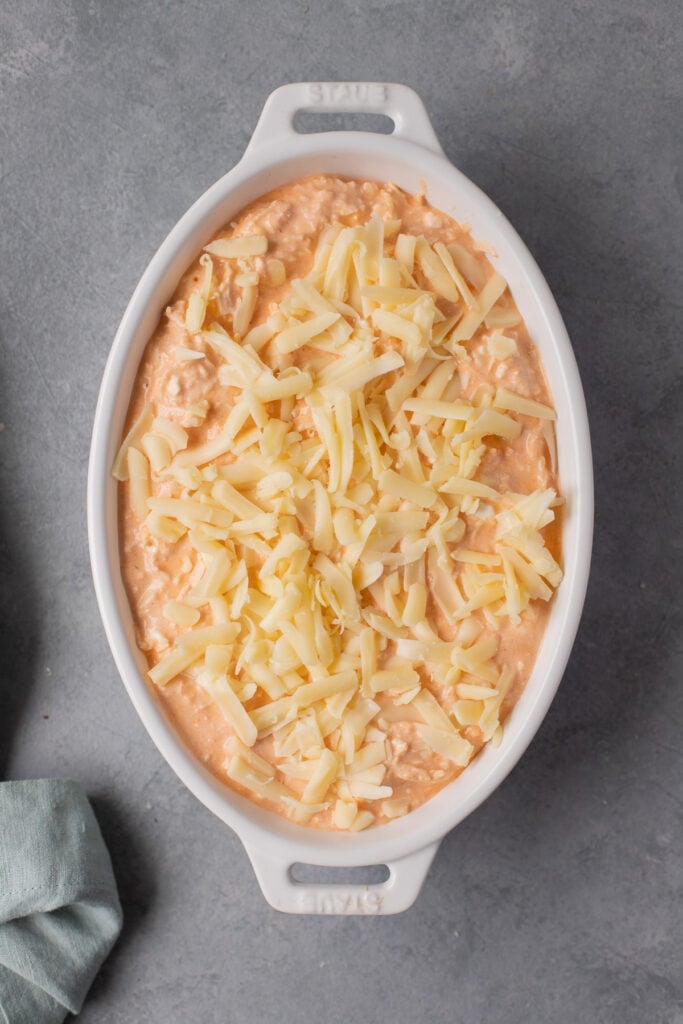 an overhead image of skinny buffalo chicken dip in a white dish before going in the oven