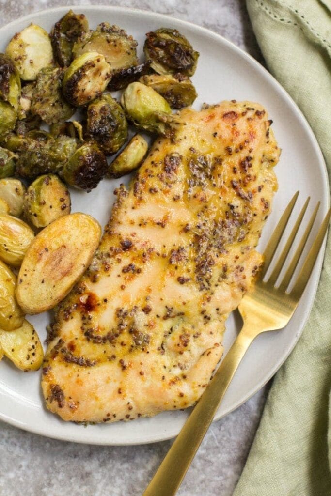 A piece of maple mustard chicken on a plate - healthy chicken breast recipes!