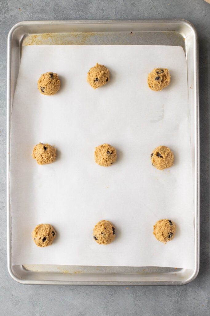 healthy whole wheat chocolate chip cookies on a parchment lined baking sheet before they go in the oven.
