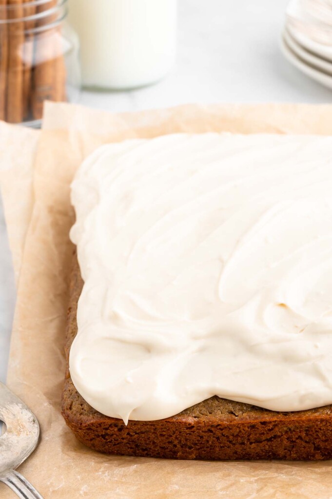 A healthy carrot cake with healthy cream cheese frosting on a parchment paper