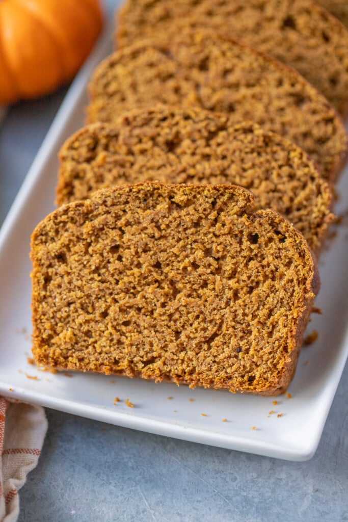 A close up of healthy pumpkin bread on a white dish on a grey background