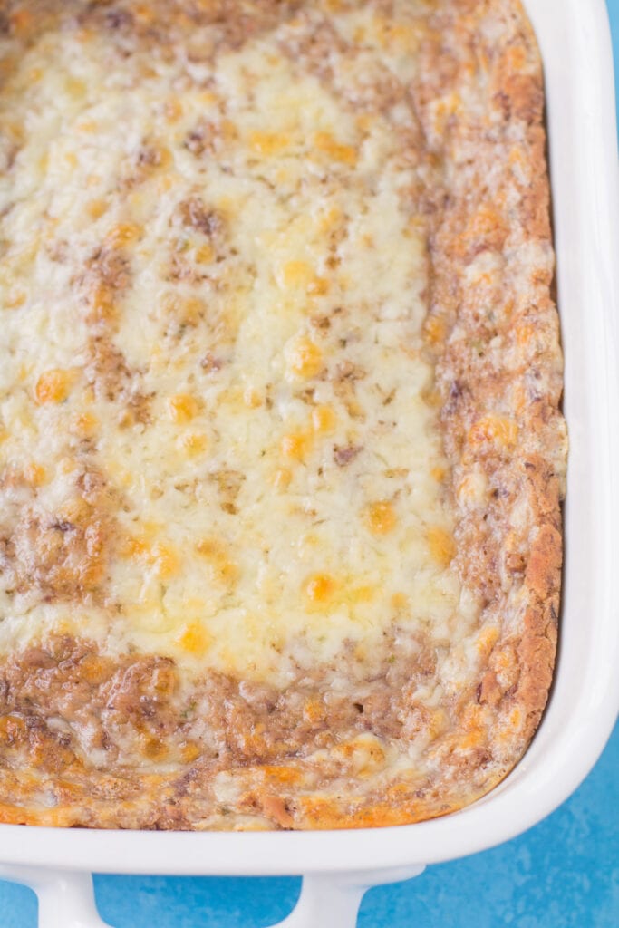 A straight on overhead shot of healthy bean dip in a white dish fresh out of the warm oven.