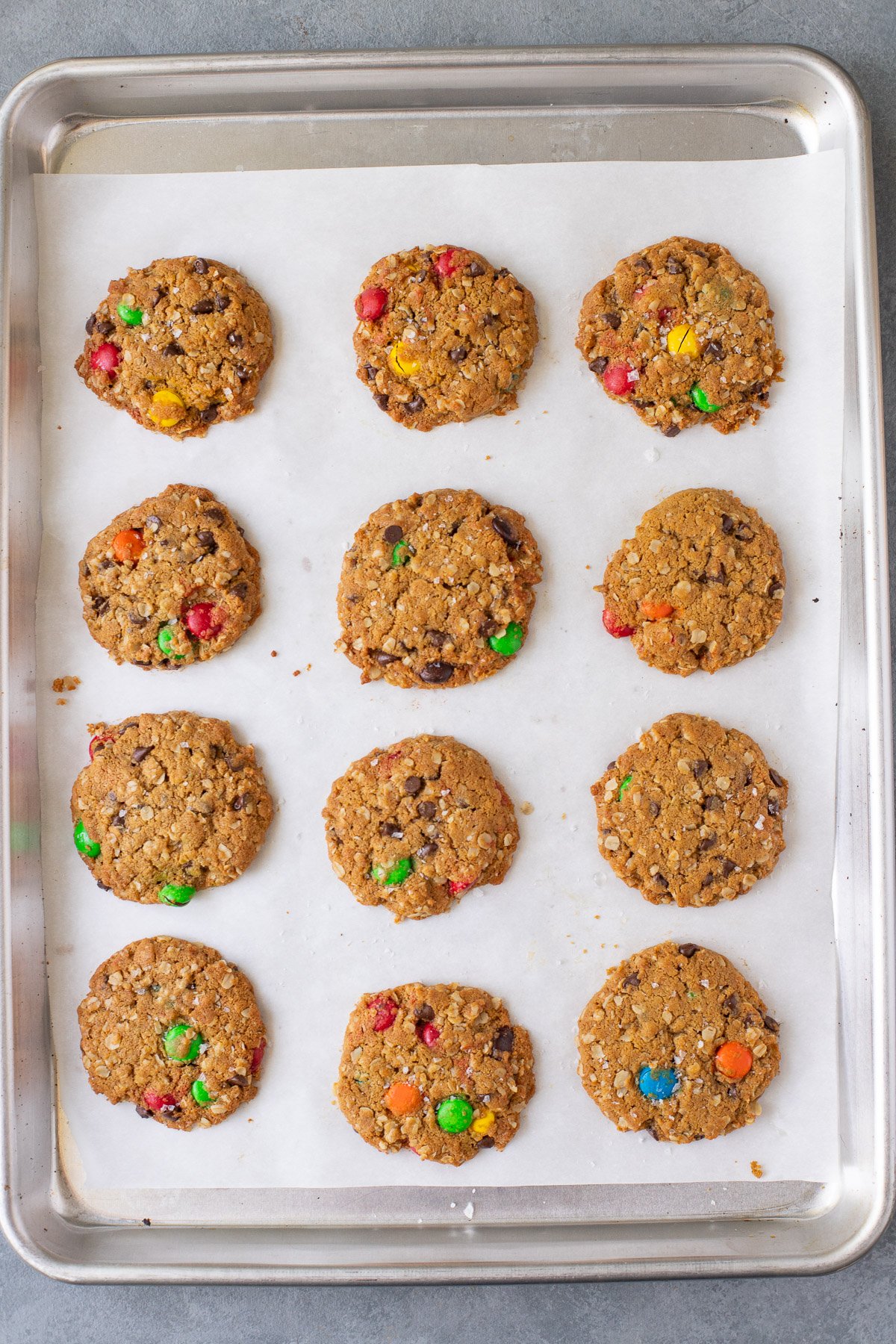 Healthy Monster Cookies on a parchment lined baking sheet after baking