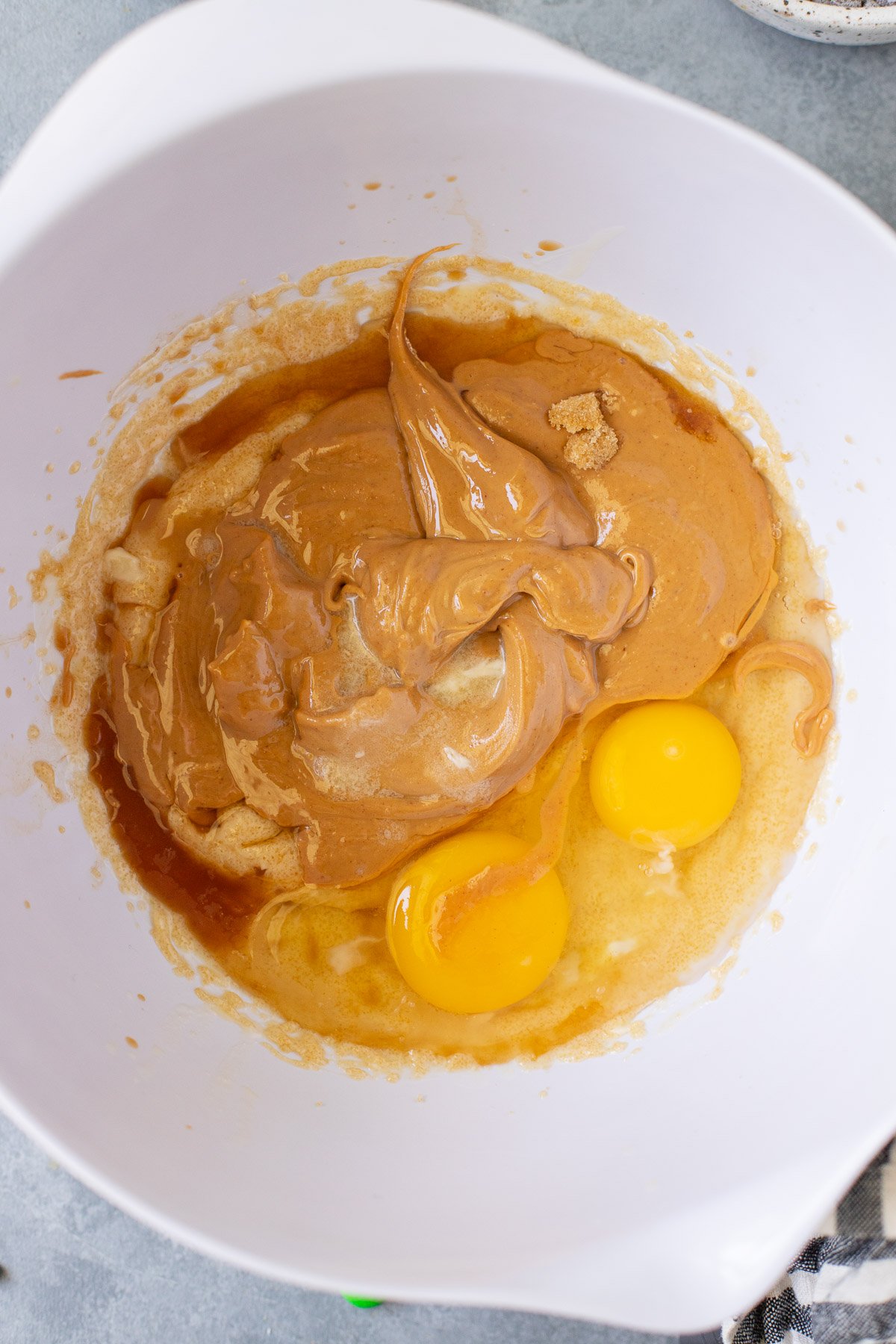 creamy peanut butter, eggs, and vanilla added to creamed butter and sugar for healthy monster cookies before being mixed