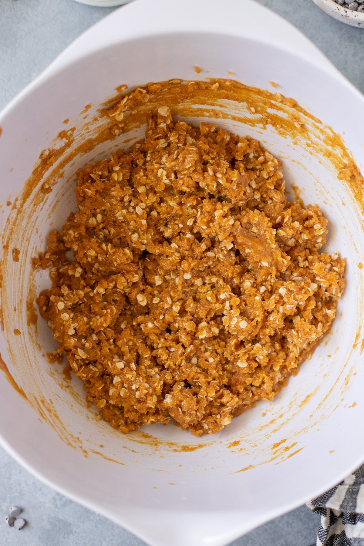 healthy monster cookie dough in a white bowl before chocolate chips and m&ms are added