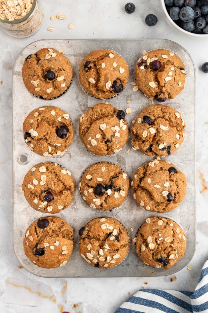 An overhead shot of a 12 muffin pan with healthy blueberry muffins 