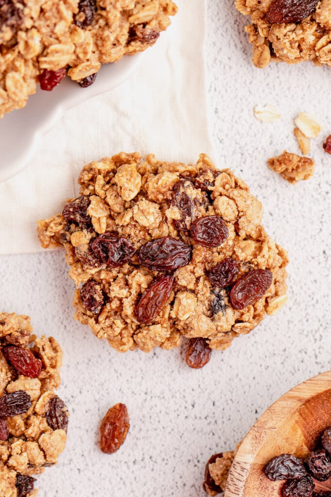 An overhead shot of a healthy oatmeal raisin cookies on a baking sheet with other cookies around it