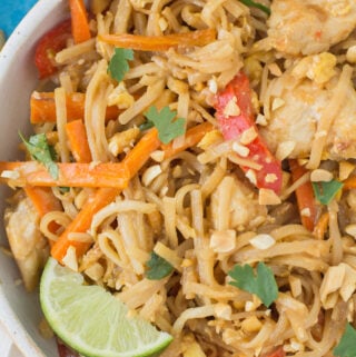 a bowl of Healthy Chicken Pad Thai on a bright blue background