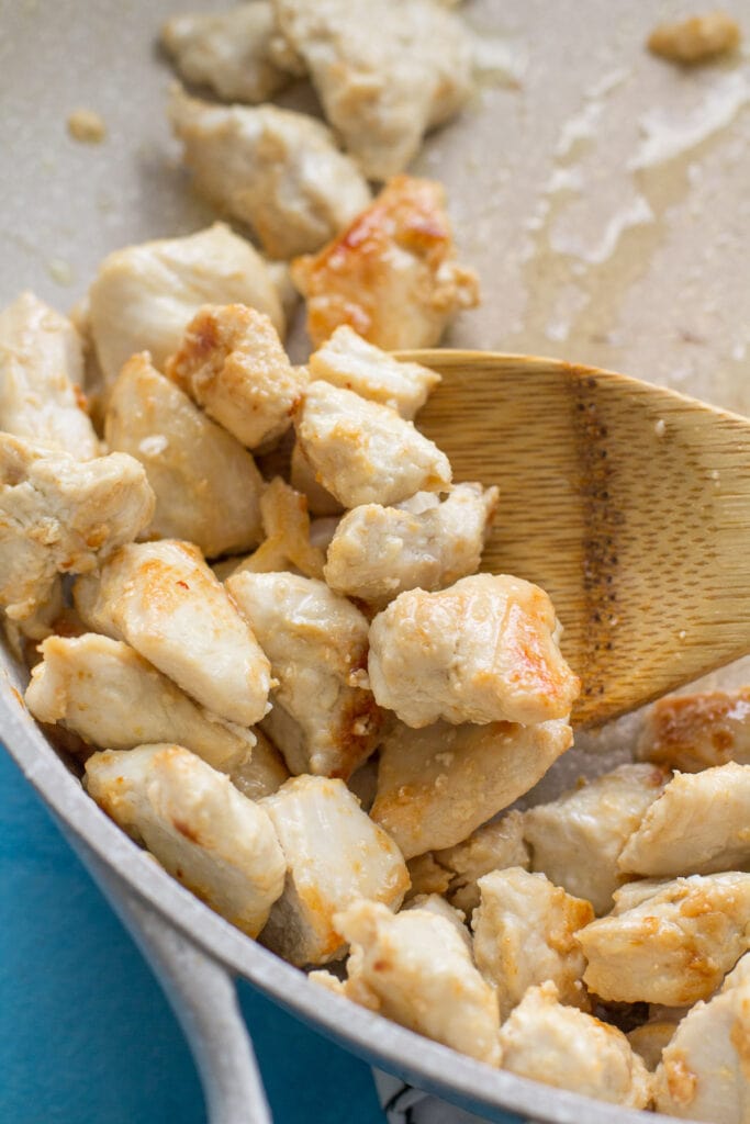 Chicken browning for healthy pad thai in a white pan