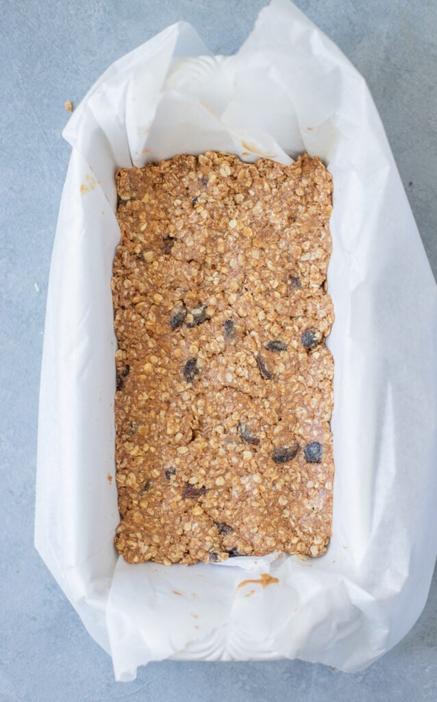 Oatmeal Raisin healthy protein bars in a parchment lined baking pan