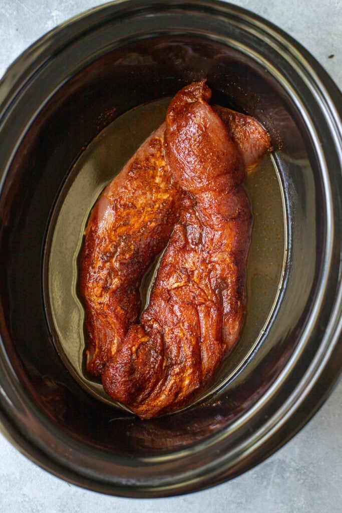 Two pork tenderloins in the crockpot before being cooked for healthy pulled pork