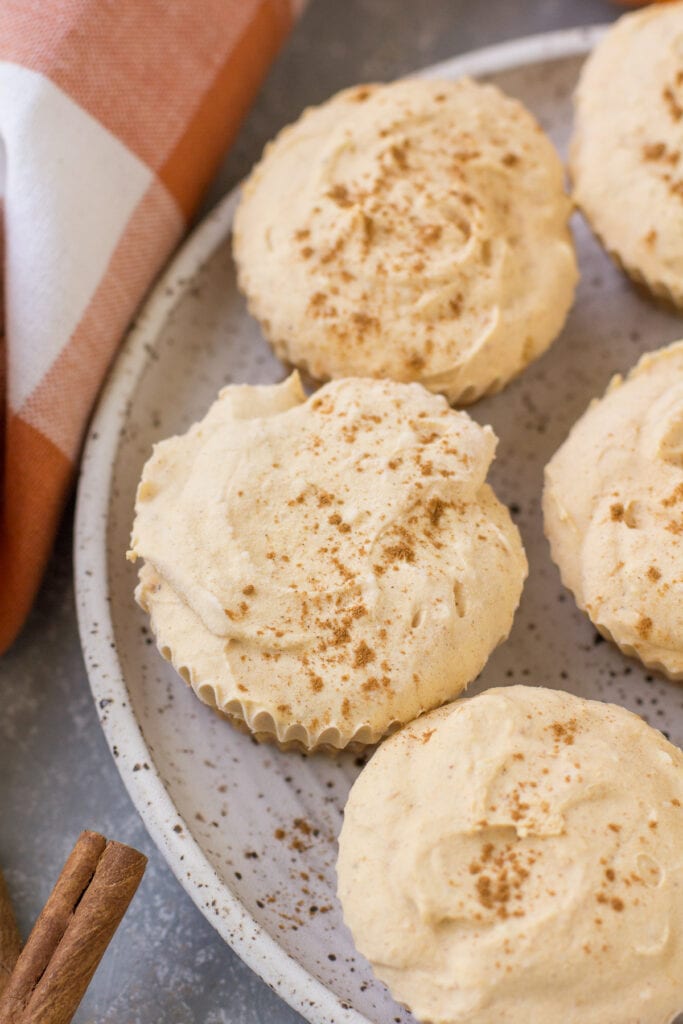 A close up of mini healthy Pumpkin Cheesecakes on a white speckled plate