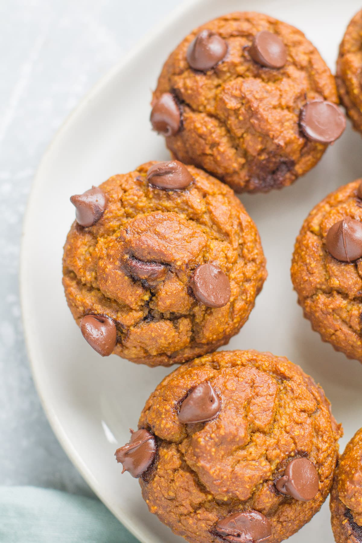 Healthy Pumpkin Muffins on a white plate with a blue linen off to the left corner