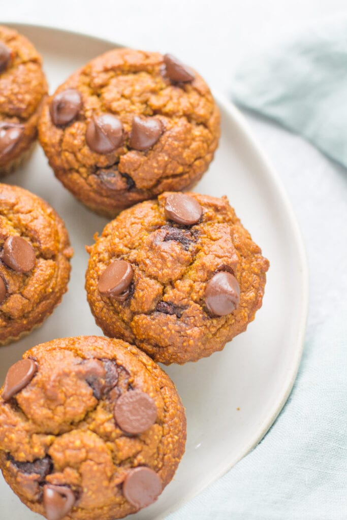 Healthy Pumpkin Muffins on a white plate with a blue linen off to the side.