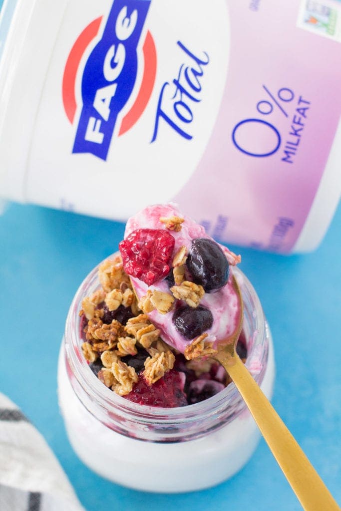 A berry healthy yogurt parfait with a spoonful taken out.