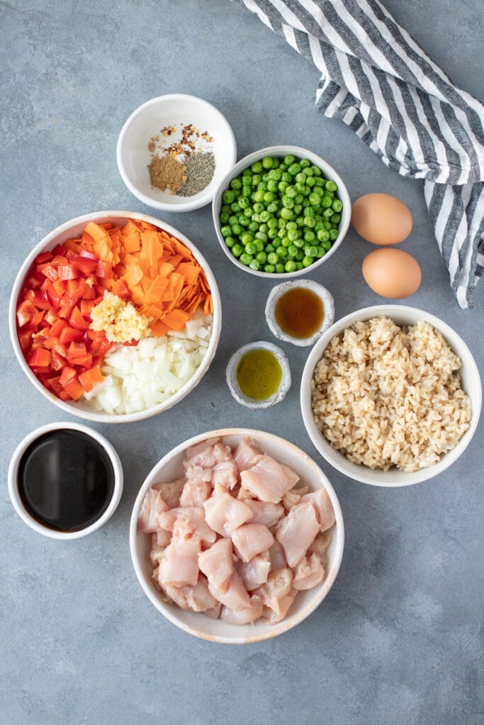Ingredients for Healthy Fried Rice in small white bowls on a grey background