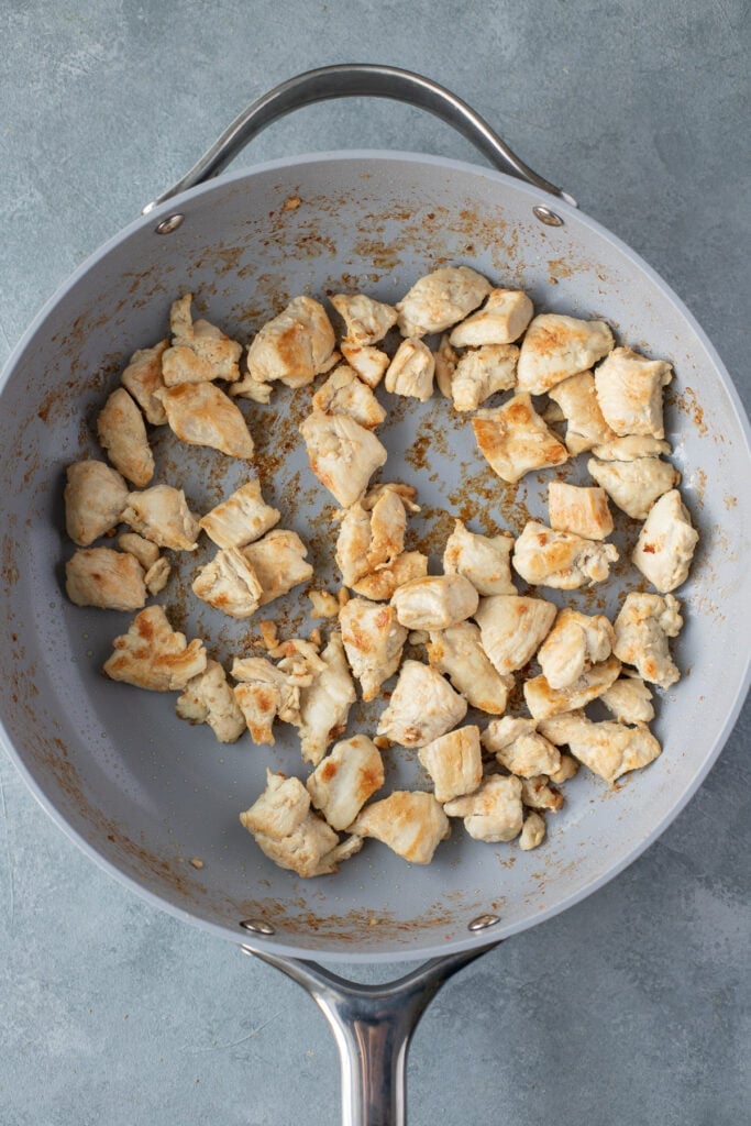 chicken browning in a pan for homemade fried rice
