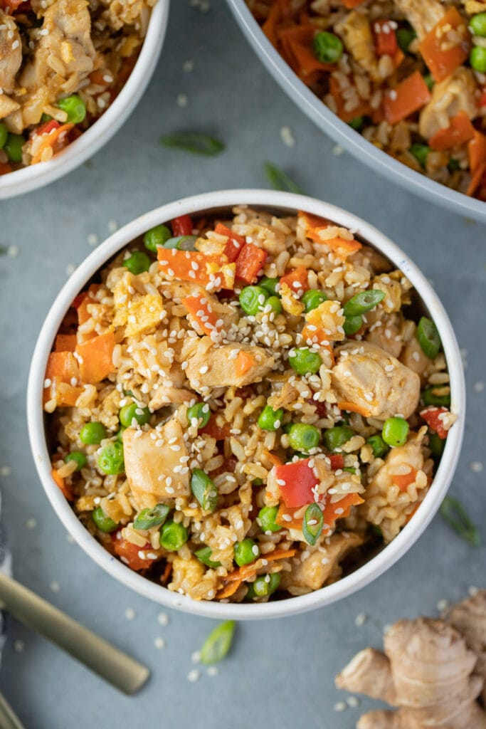 Fried rice in a white bowl on a grey background. 