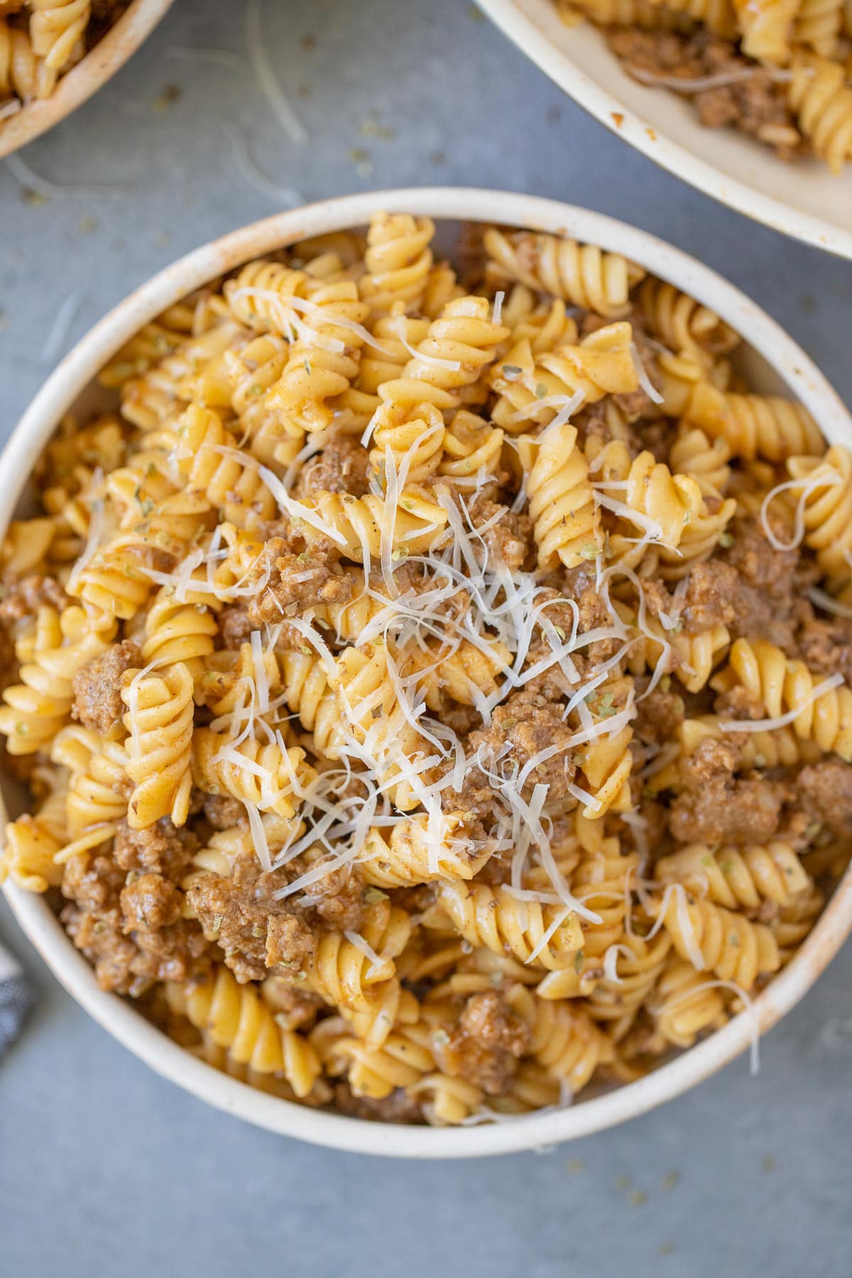 A close up of a bowl of homemade hamburger helper on a grey background