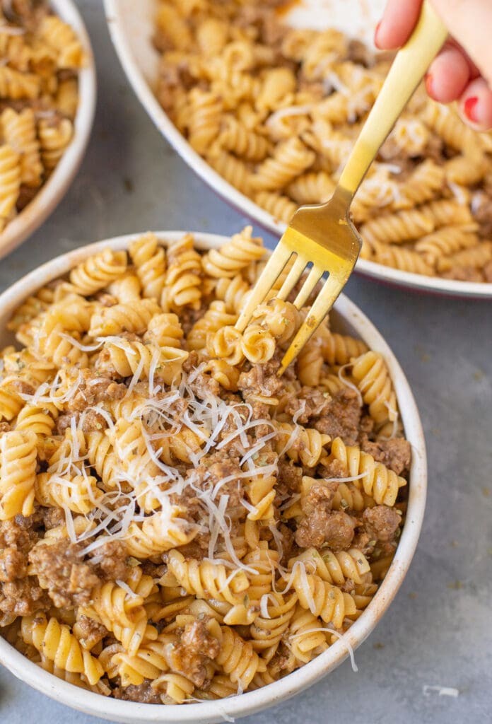 A fork taking a bite out of a bowl of homemade hamburger helper