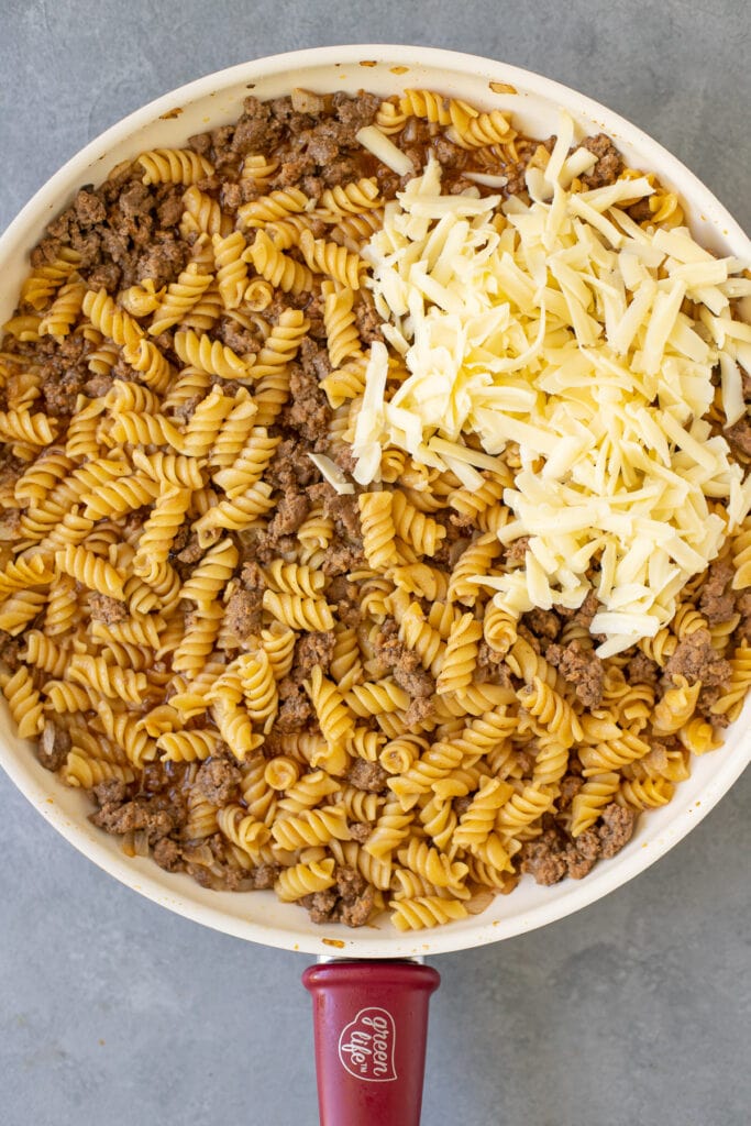 cheese being stirred into a pan for easy hamburger helper
