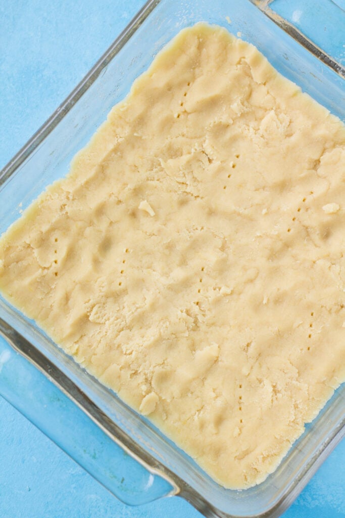 Crust for easy healthy lemon bars in a glass baking dish before going in the oven