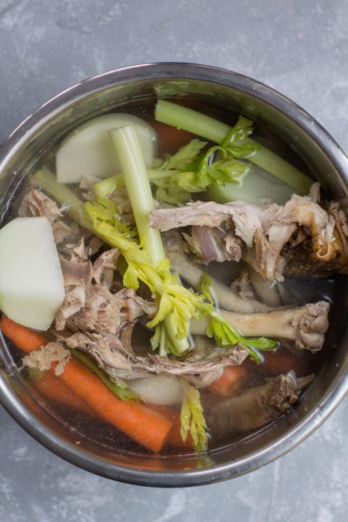 A close up of instant pot bone broth in the instant pot insert before it has cooked