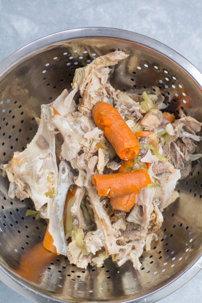a close up of instant pot bone broth being run through a strainer