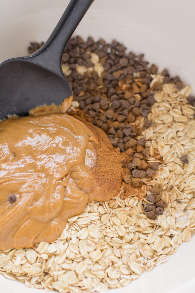 a bowl of peanut butter granola being mixed together