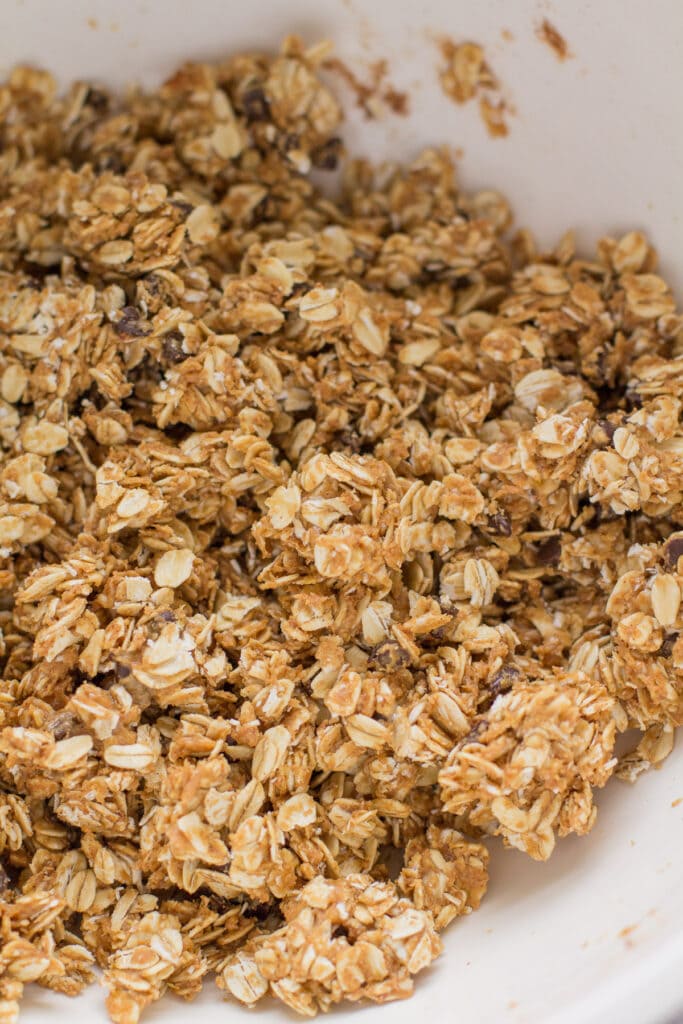 peanut butter granola being poured onto a cookie sheet