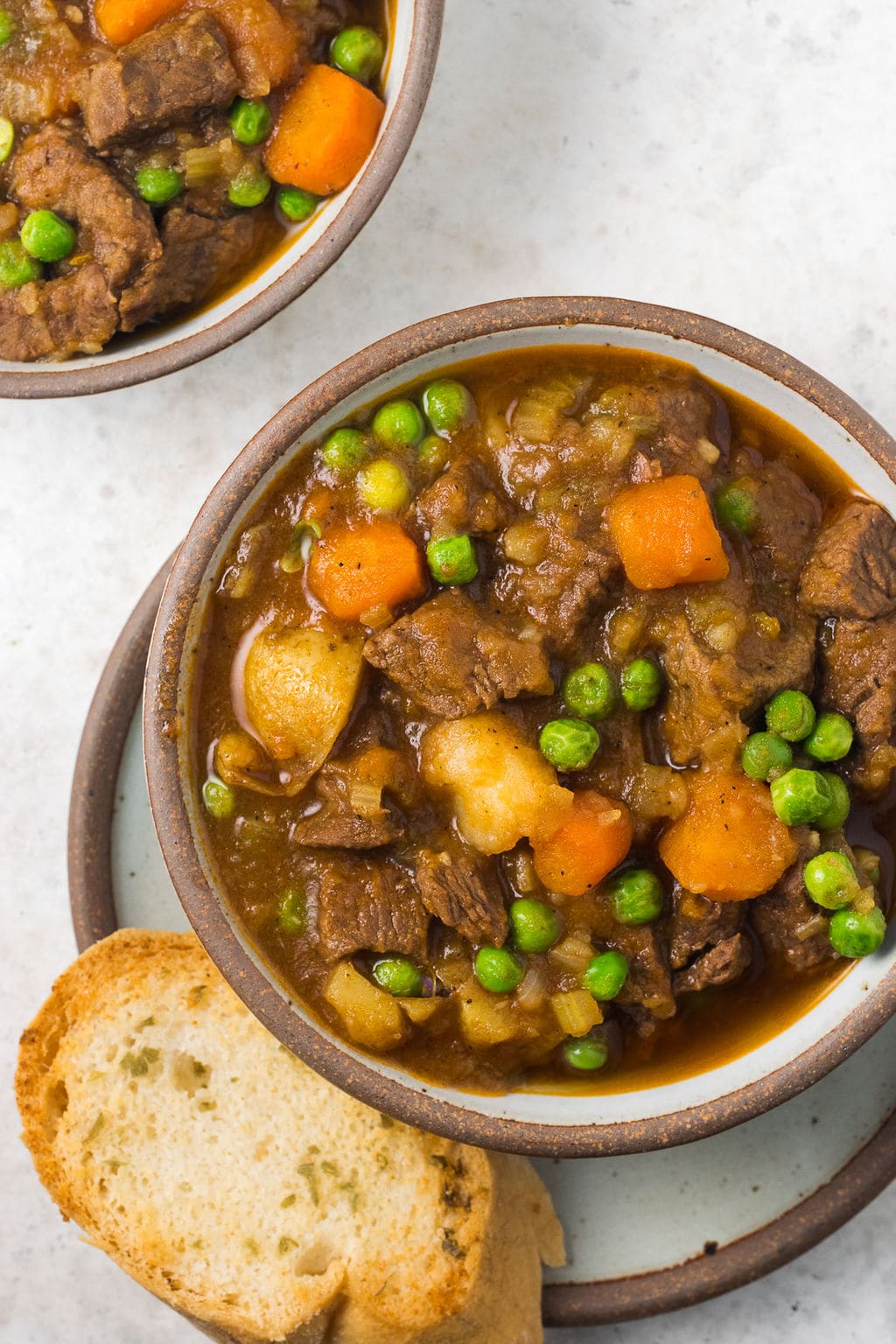 A bowl of instant pot beef stew on a light grey background
