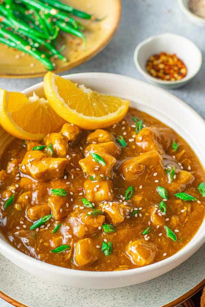 A close up of instant pot orange chicken in a bowl after it has been cooked