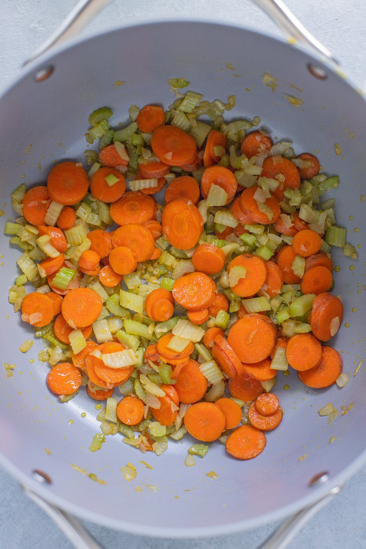 An overhead shot of a pot of carrots, celery being cooked for Italian Wedding Soup