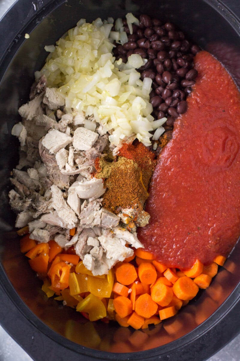 Ingredients for leftover turkey chili in a crockpot base before stirring together or cooking.