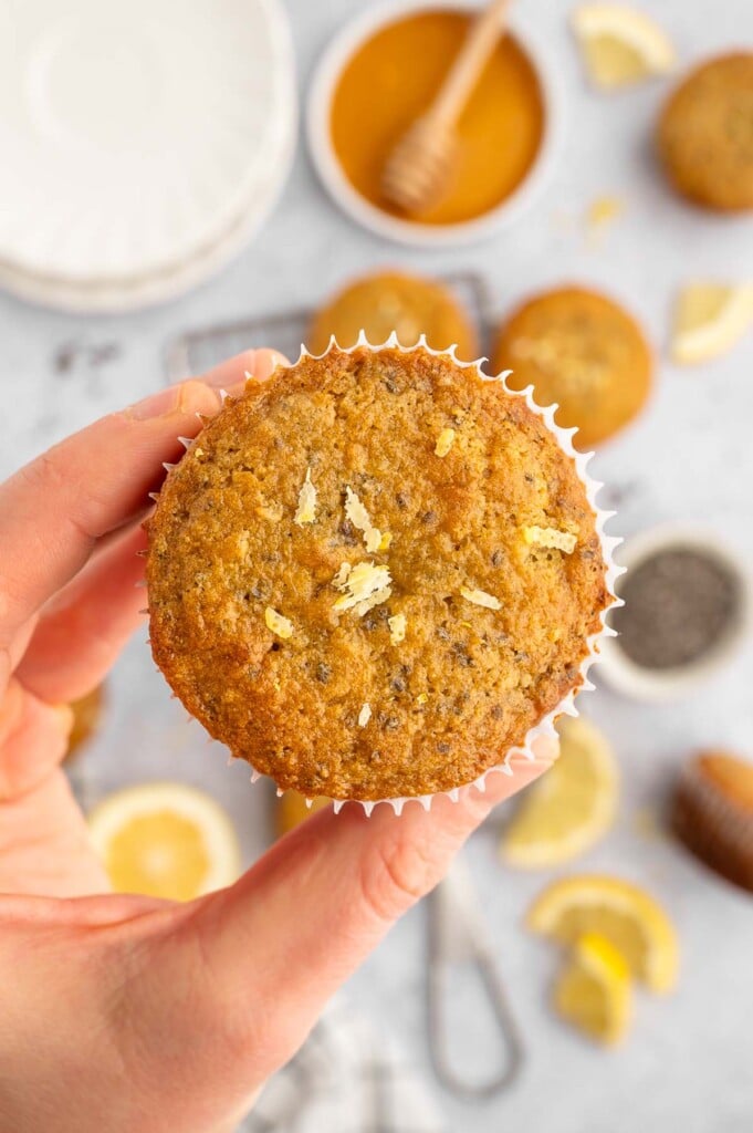 A hand holding up a lemon chia seed muffin. 
