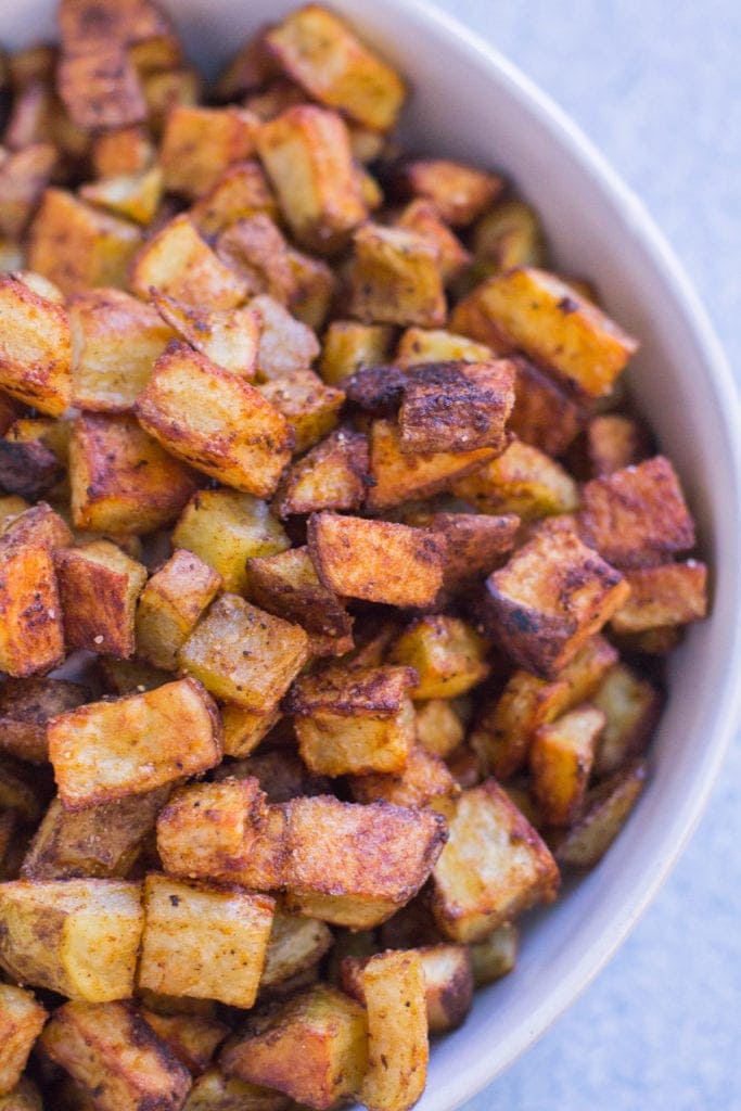 a big white bowl filled with crispy mexican potatoes