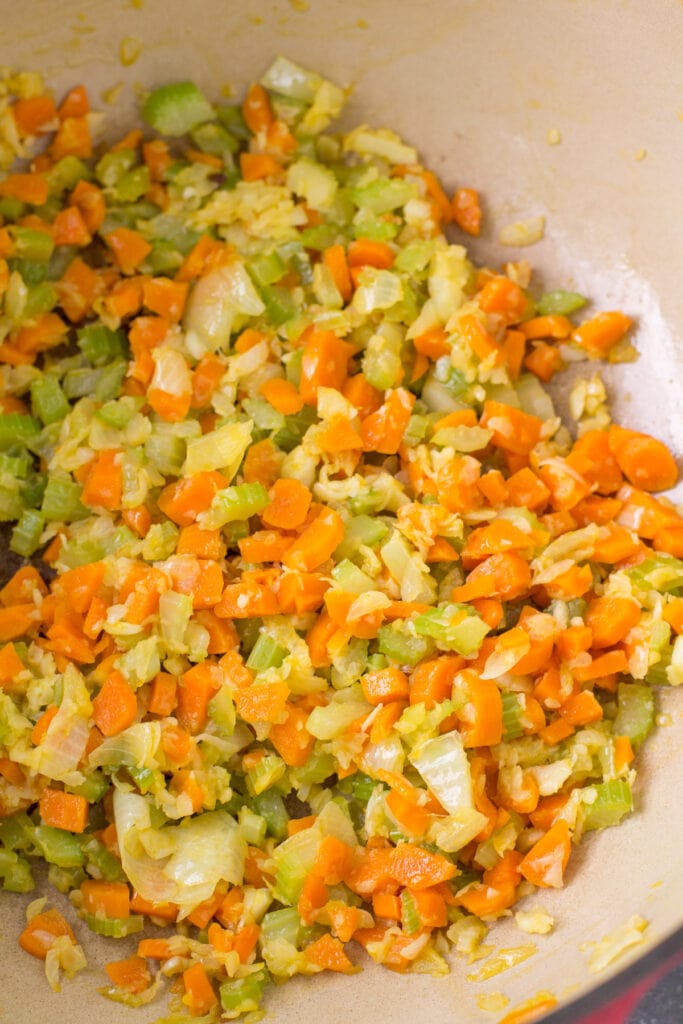 Veggies sauteing in a dutch oven for minestrone soup