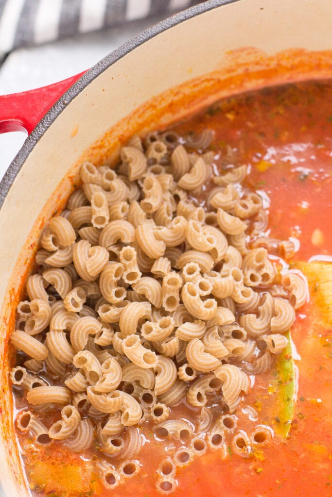 Pasta being added to easy minestrone recipe in a big pot