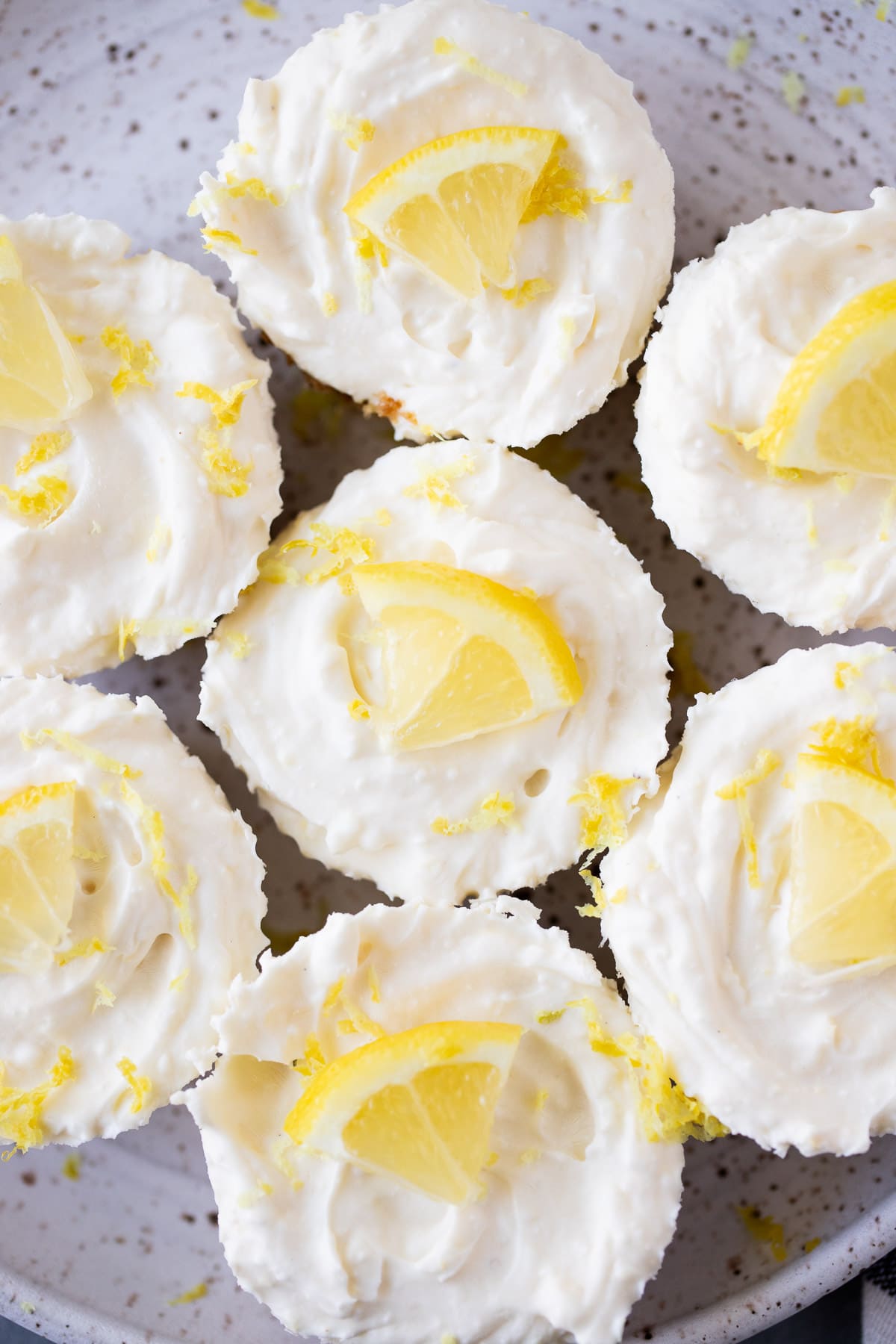Mini lemon cheesecakes on a small white speckled plate