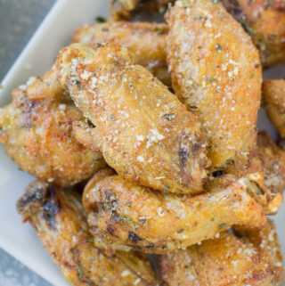 Parmesan Chicken Wings on a white plate on a grey background.