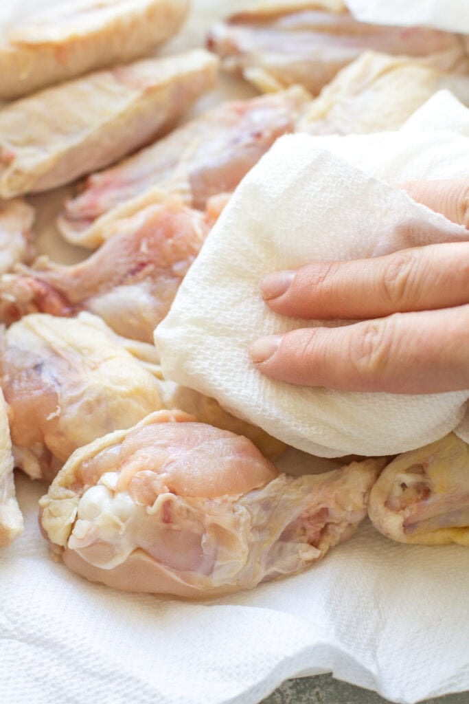 Parmesan Chicken Wings being patted dry before being cooked