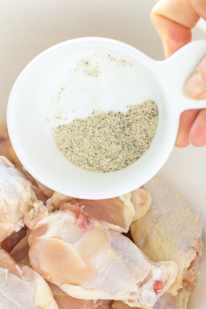 Dry rub for Parmesan Chicken Wings being poured into a white bowl