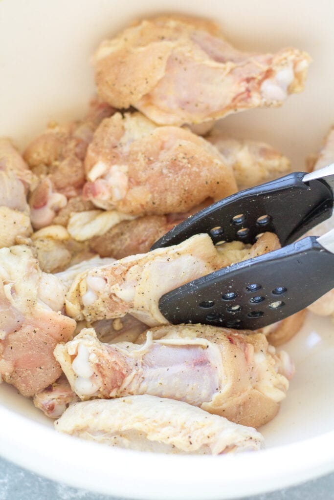 Parmesan Chicken Wings being tossed until coated in a dry rub