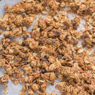 An overhead shot of peanut butter granola on a parchment lined baking sheet.