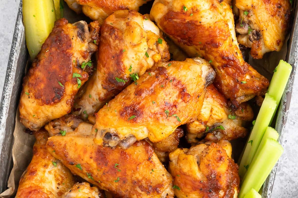 A close up of pickle chicken wings and celery sticks. 