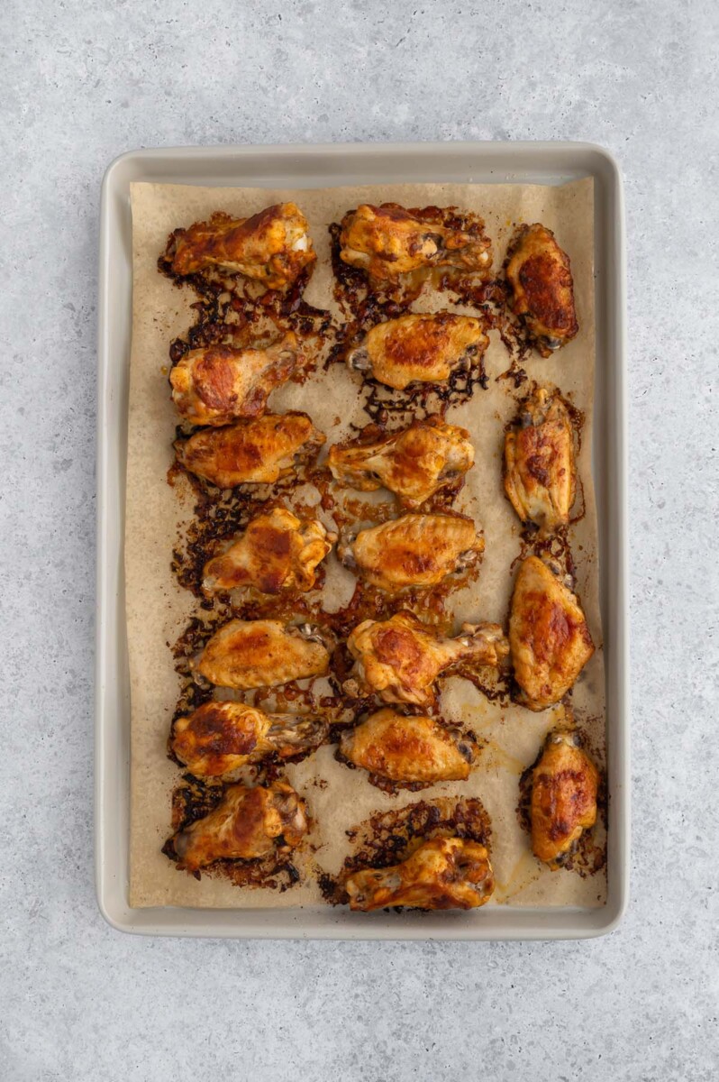 Pickle chicken wings on a parchment lined baking sheet right after cooking.
