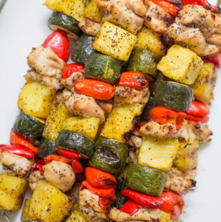 Pineapple Chicken Kabobs piled high on a white plate