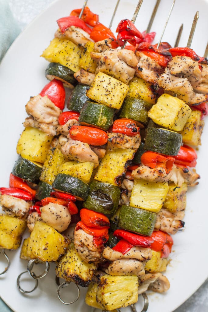 Pineapple Chicken Kabobs piled high on a white plate