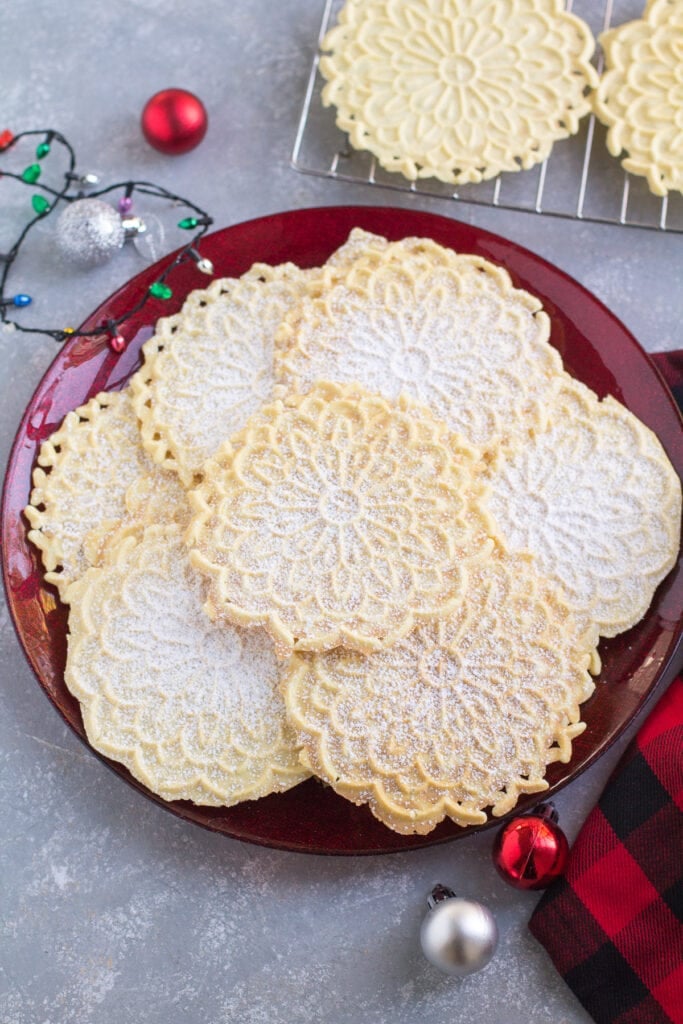 Pizzelle on a red holiday plate - an Italian vanilla cookie everyone loves!